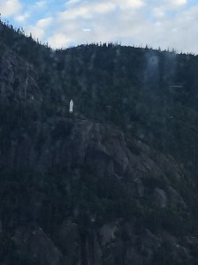 Hard to see statue of Mary along the fjord